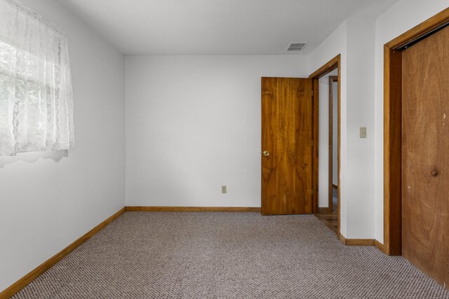 849 N Piatt St, Bement, IL 61813 - unfurnished bedroom featuring carpet, a closet, and baseboards