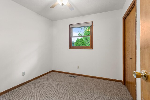 849 N Piatt St, Bement, IL 61813 - unfurnished bedroom with carpet flooring, baseboards, a closet, and ceiling fan