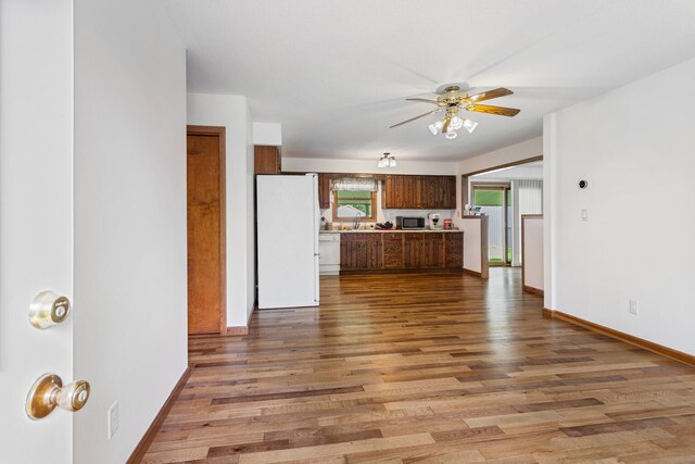 849 N Piatt St, Bement, IL 61813 - kitchen with white appliances, ceiling fan, light wood-style flooring, and baseboards