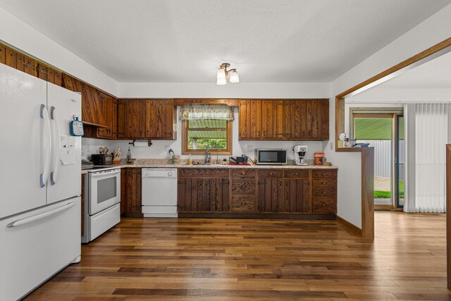 849 N Piatt St, Bement, IL 61813 - kitchen featuring white appliances, a sink, dark wood-style flooring, and light countertops