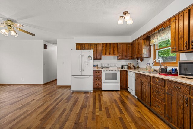 849 N Piatt St, Bement, IL 61813 - kitchen featuring white appliances, dark wood-style floors, ceiling fan, light countertops, and a sink