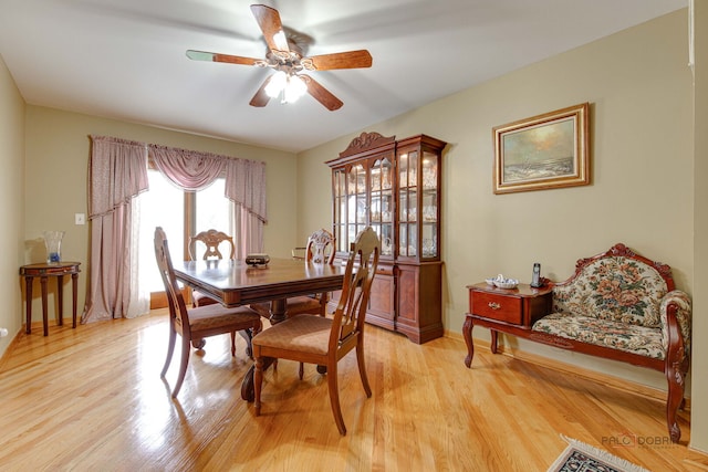 dining area featuring light wood-style flooring, a ceiling fan, and baseboards