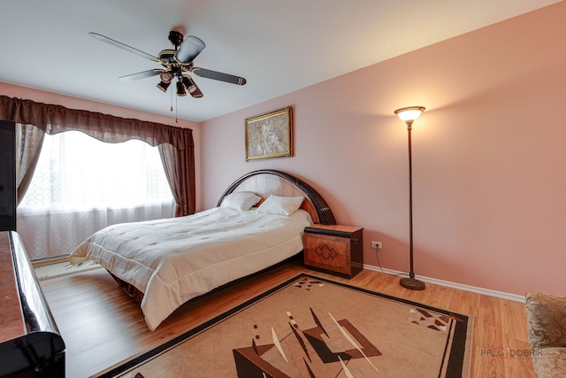 bedroom with wood finished floors, baseboards, and ceiling fan