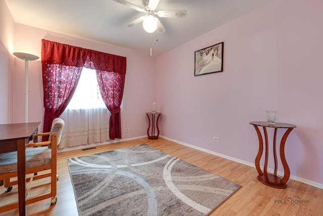 office area featuring a ceiling fan, wood finished floors, and baseboards