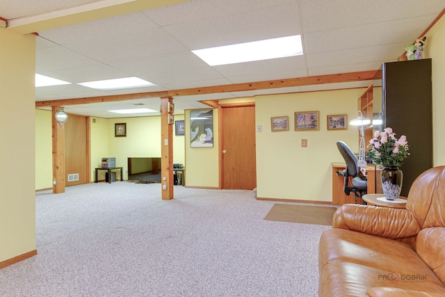 living room featuring carpet floors, a paneled ceiling, and baseboards