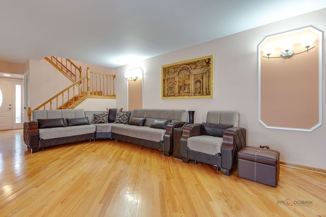 living area with wood finished floors, stairway, and baseboards