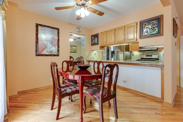 dining area featuring ceiling fan, light wood-style floors, arched walkways, and baseboards