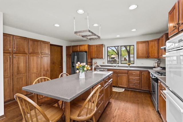112 Braemar Dr, Elk Grove Village, IL 60007 - kitchen featuring stainless steel appliances, a sink, brown cabinets, recessed lighting, and dark wood-style flooring