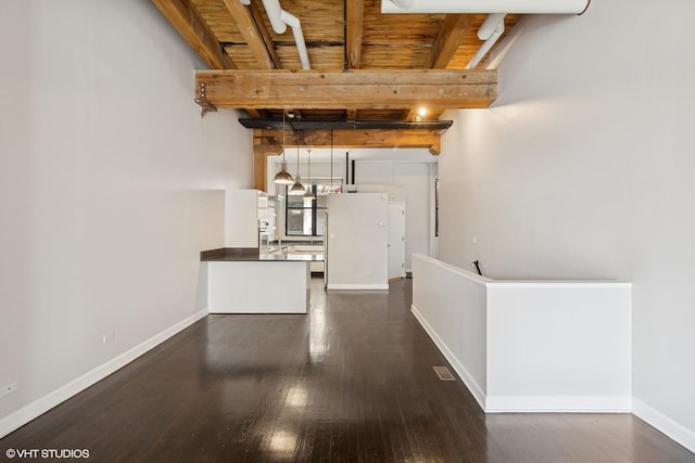 interior space featuring wood ceiling, beamed ceiling, dark wood-style flooring, and baseboards