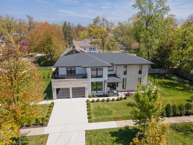 view of front of home with stone siding, concrete driveway, a shingled roof, and a garage