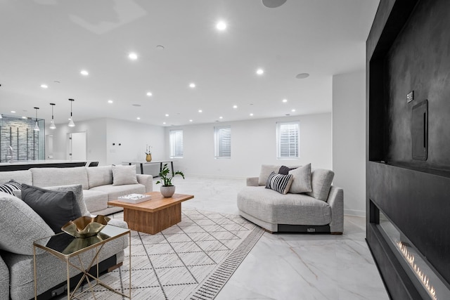 living area featuring light marble finish floors, recessed lighting, a fireplace, and baseboards