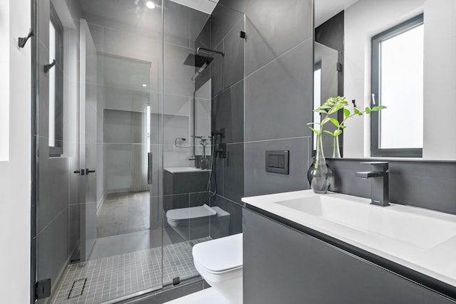 bathroom featuring toilet, a shower stall, and vanity
