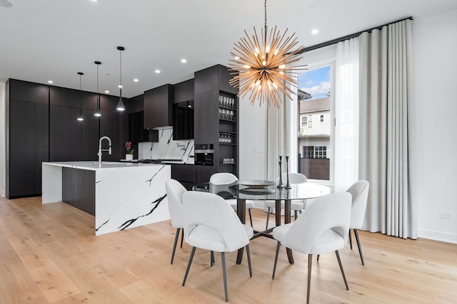 dining area featuring a chandelier, light wood-type flooring, and recessed lighting