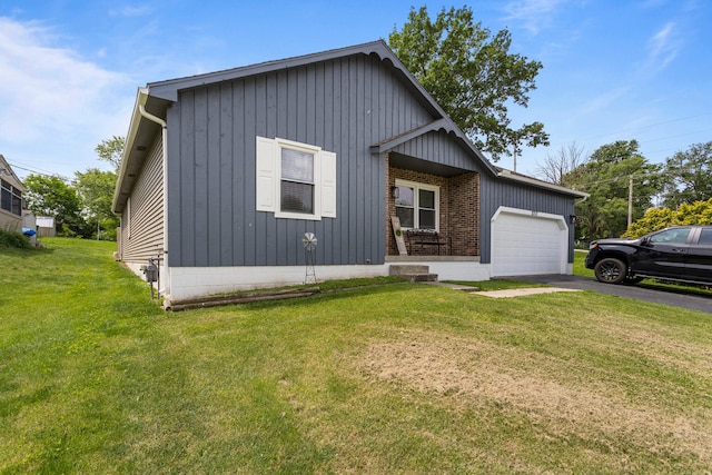 2717 E Main St, Decatur, IL 62521 - view of front of house featuring an attached garage, asphalt driveway, a front yard, and board and batten siding