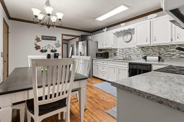 2717 E Main St, Decatur, IL 62521 - kitchen with black dishwasher, a sink, crown molding, a chandelier, and tasteful backsplash