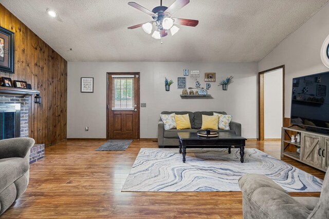 2717 E Main St, Decatur, IL 62521 - living room with a textured ceiling, wooden walls, ceiling fan, lofted ceiling, and wood finished floors