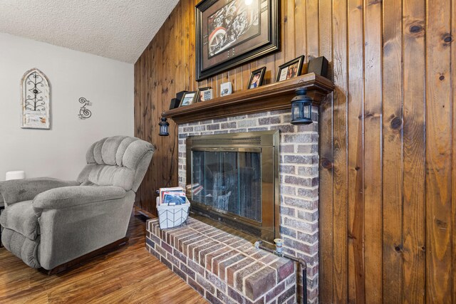 2717 E Main St, Decatur, IL 62521 - living room with wood walls, a textured ceiling, wood finished floors, and a fireplace
