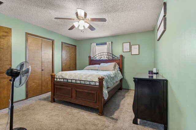 2717 E Main St, Decatur, IL 62521 - bedroom with light carpet, two closets, a textured ceiling, and ceiling fan