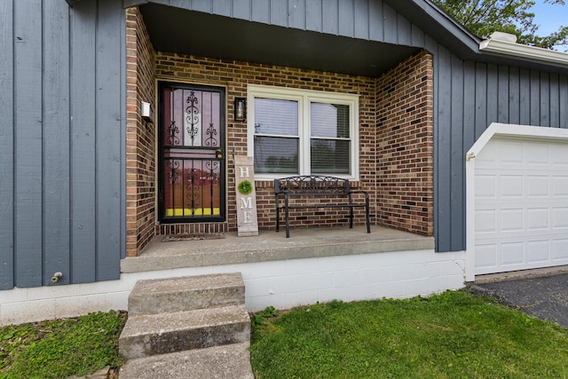 2717 E Main St, Decatur, IL 62521 - property entrance featuring a garage, covered porch, brick siding, and board and batten siding
