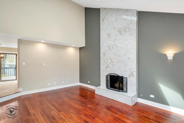 2639 E Shady Grove Ct, Crete, IL 60417 - unfurnished living room featuring wood finished floors, a large fireplace, baseboards, and a towering ceiling