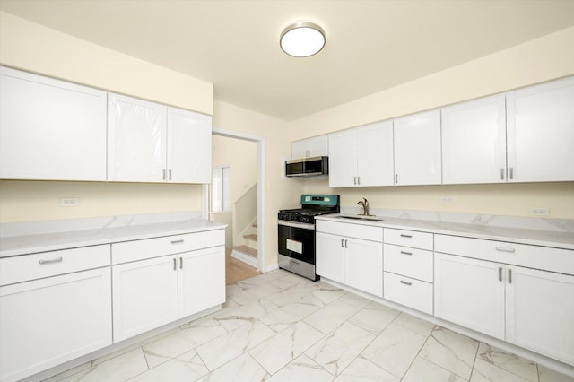 236 Early St, Park Forest, IL 60466 - kitchen featuring stainless steel appliances, light marble finish flooring, a sink, and white cabinets