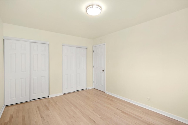 236 Early St, Park Forest, IL 60466 - unfurnished bedroom with multiple closets, baseboards, and light wood finished floors