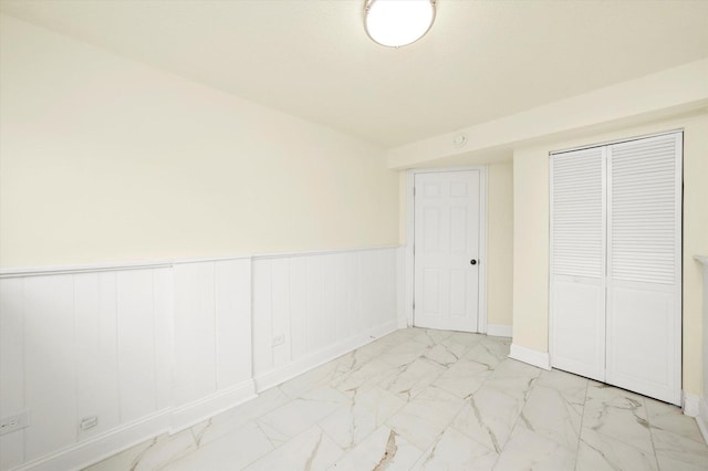 236 Early St, Park Forest, IL 60466 - unfurnished bedroom featuring marble finish flooring, a closet, wainscoting, and baseboards