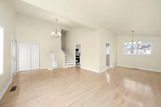236 Early St, Park Forest, IL 60466 - unfurnished living room with a chandelier, light wood-style floors, stairs, baseboards, and high vaulted ceiling
