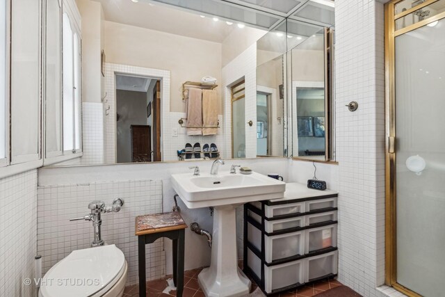 bathroom with tile walls, toilet, a stall shower, and tile patterned flooring