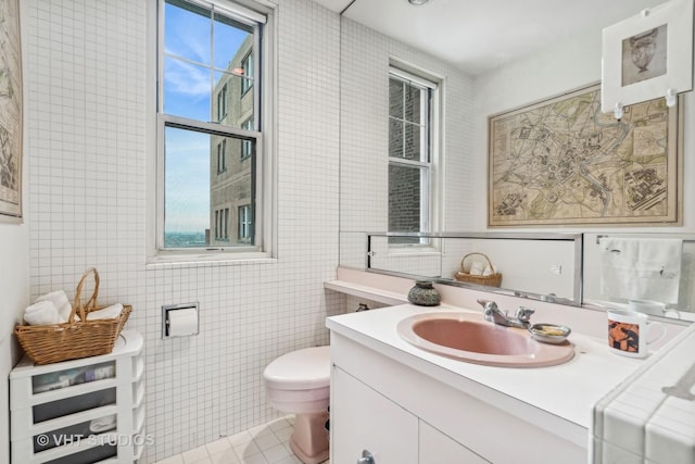 bathroom featuring tile walls, toilet, vanity, and tile patterned flooring