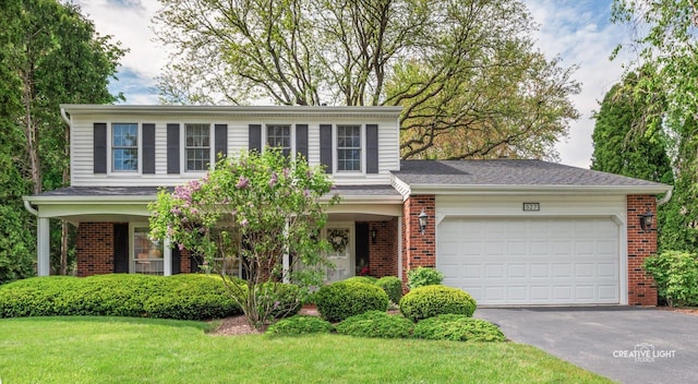 view of front of house featuring asphalt driveway, brick siding, a garage, and a front yard