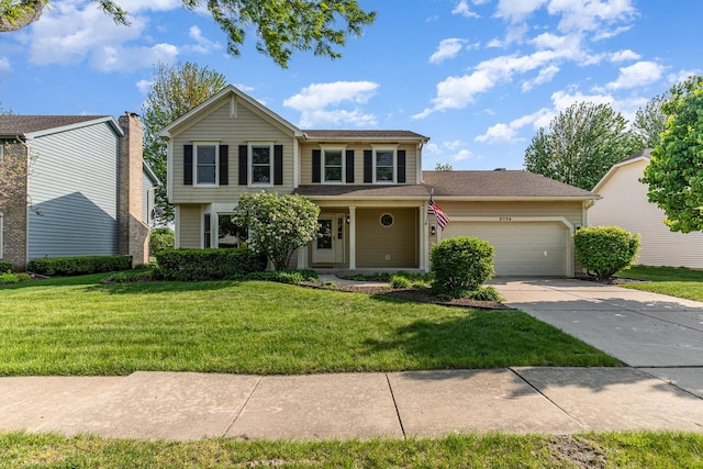 traditional-style home with an attached garage, concrete driveway, and a front yard