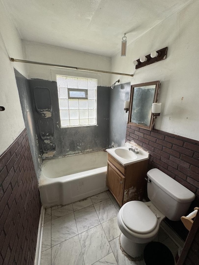 full bath featuring toilet, marble look tile flooring, shower / washtub combination, vanity, and wainscoting