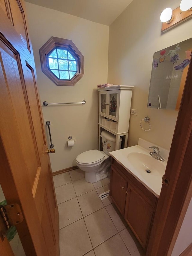 half bathroom with tile patterned flooring, toilet, and vanity