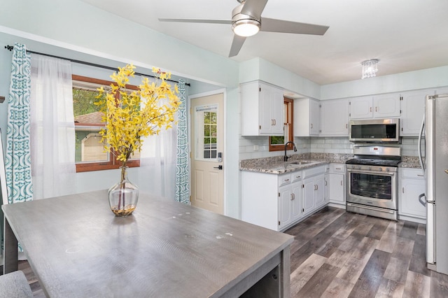 1339 Addleman St, Joliet, IL 60431 - kitchen with appliances with stainless steel finishes, a sink, backsplash, white cabinets, and dark wood-type flooring