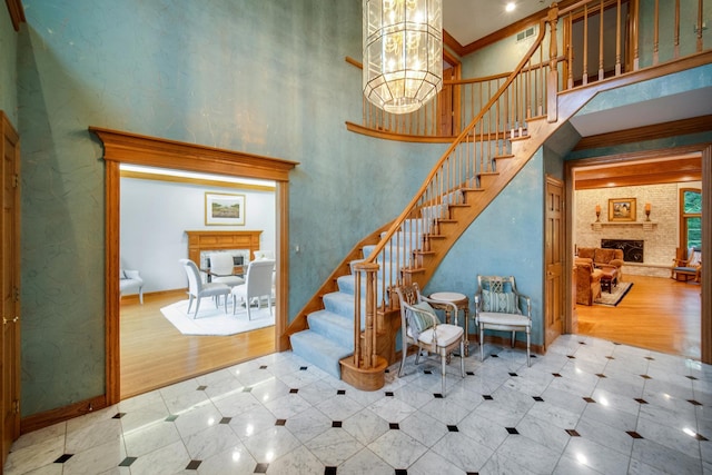 160 Circle Ridge Dr, Burr Ridge, IL 60527 - stairs with a large fireplace, a towering ceiling, baseboards, tile patterned floors, and a chandelier