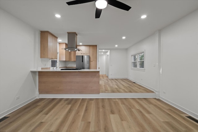 1416 3rd St, Winthrop Harbor, IL 60096 - kitchen with island exhaust hood, light countertops, freestanding refrigerator, light wood-style flooring, and a peninsula