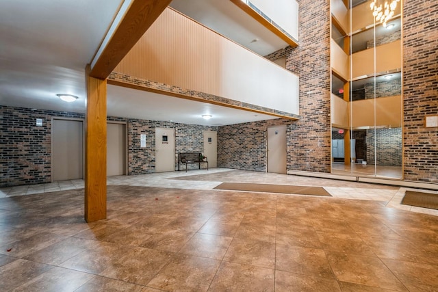 community lobby featuring brick wall and a towering ceiling