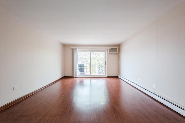 unfurnished room featuring baseboard heating, an AC wall unit, wood finished floors, and baseboards