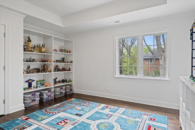 recreation room with wood finished floors, baseboards, and crown molding