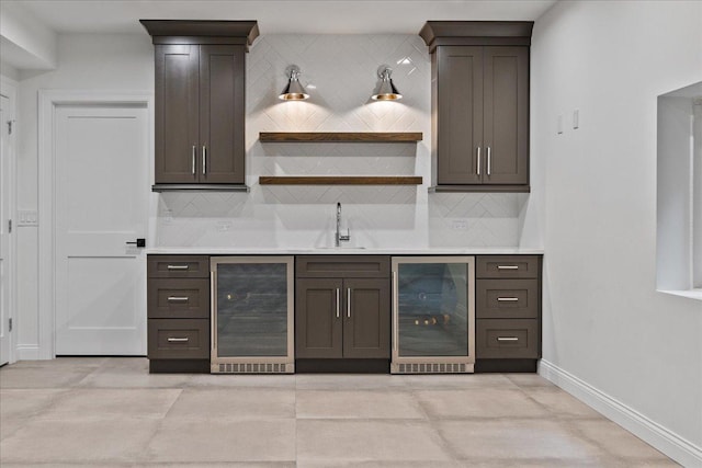 indoor wet bar with beverage cooler, backsplash, and baseboards