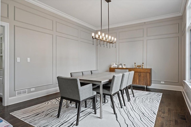 dining room with a decorative wall, ornamental molding, a chandelier, dark wood finished floors, and baseboards