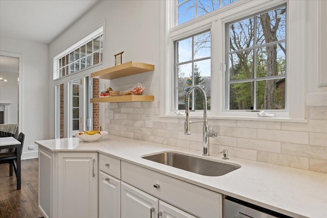 kitchen featuring a sink, tasteful backsplash, white cabinets, dark wood-type flooring, and dishwasher