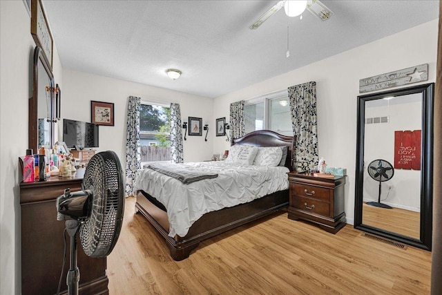 1216 N Oak St, Bloomington, IL 61701 - bedroom with light wood-type flooring, a textured ceiling, and a ceiling fan