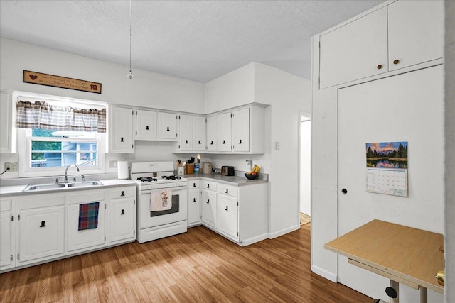 1216 N Oak St, Bloomington, IL 61701 - kitchen with white range with gas stovetop, light wood-type flooring, white cabinetry, light countertops, and a textured ceiling