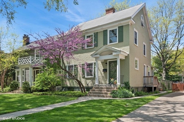 2206 Forestview Rd, Evanston, IL 60201 - view of front facade featuring a chimney, a front yard, and stucco siding