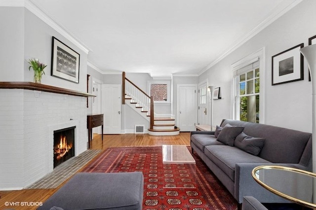 2206 Forestview Rd, Evanston, IL 60201 - living room featuring wood finished floors, stairway, a brick fireplace, and crown molding