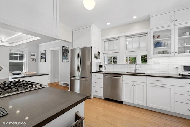 2206 Forestview Rd, Evanston, IL 60201 - kitchen featuring stainless steel appliances, a sink, dark countertops, white cabinetry, and recessed lighting