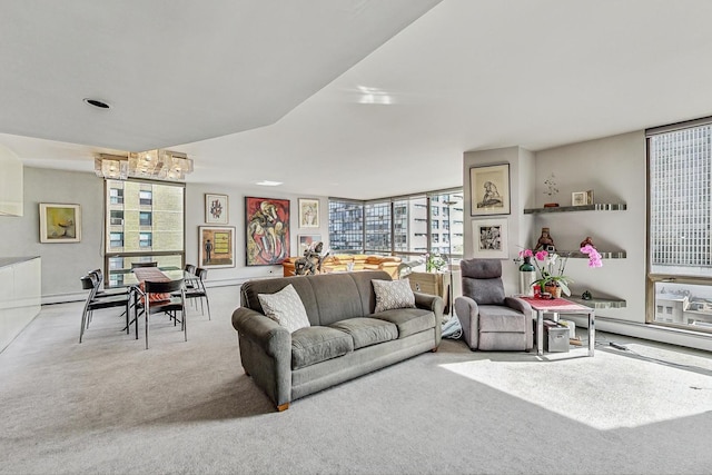 carpeted living area with plenty of natural light, a chandelier, and a wall of windows