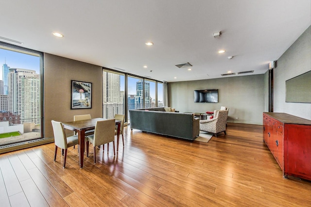 dining room with expansive windows, light wood-style floors, recessed lighting, and baseboard heating